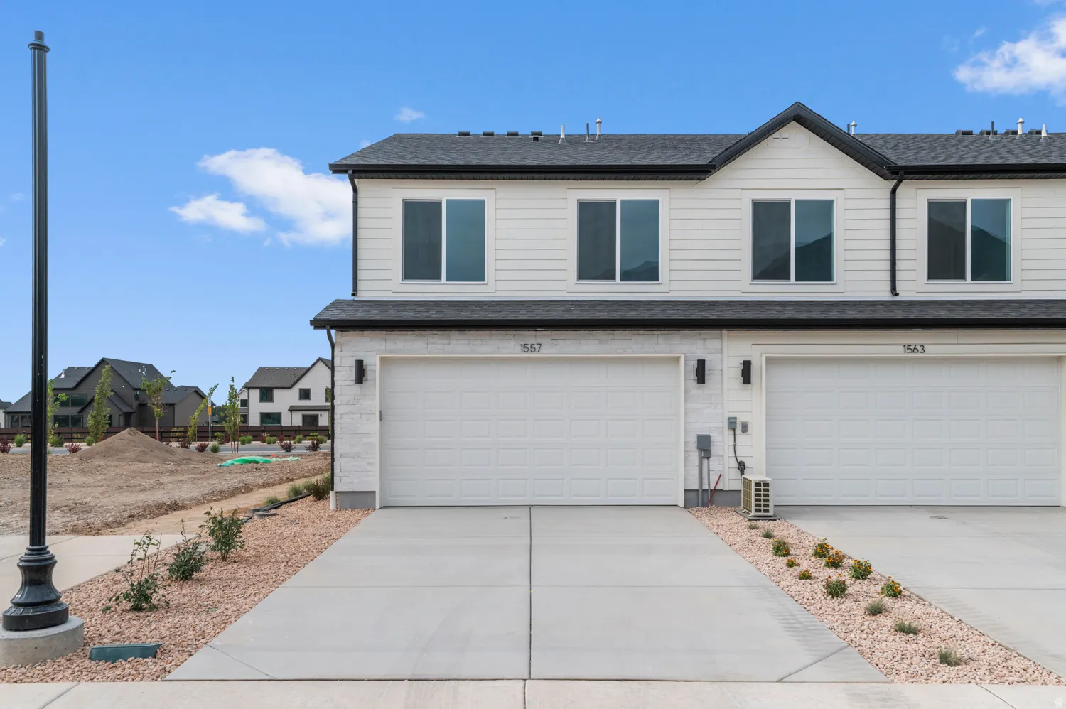 View of front of home featuring an attached garage, concrete driveway, and roof with shingles