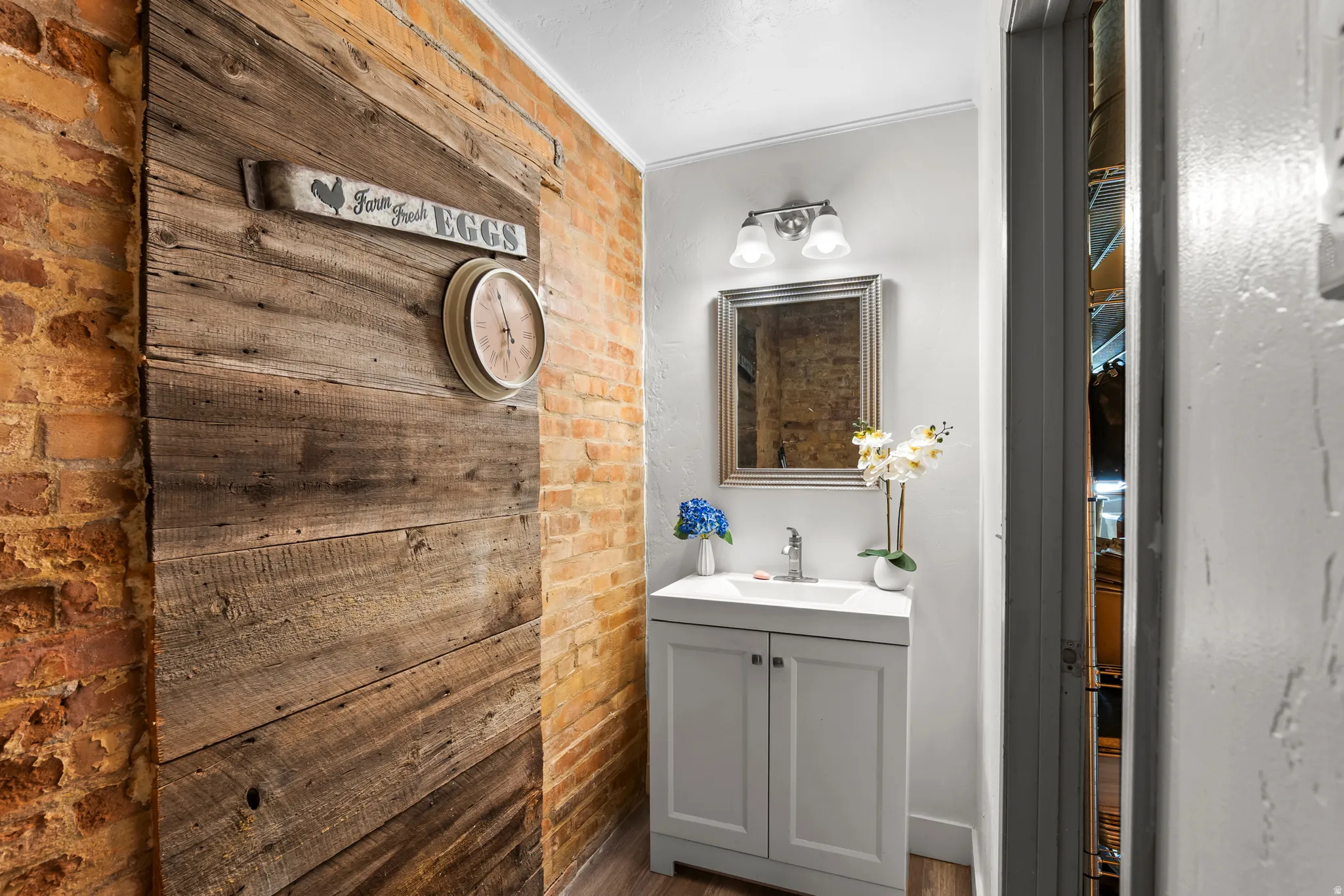 Main floor. Bathroom with brick wall, vanity, and crown molding