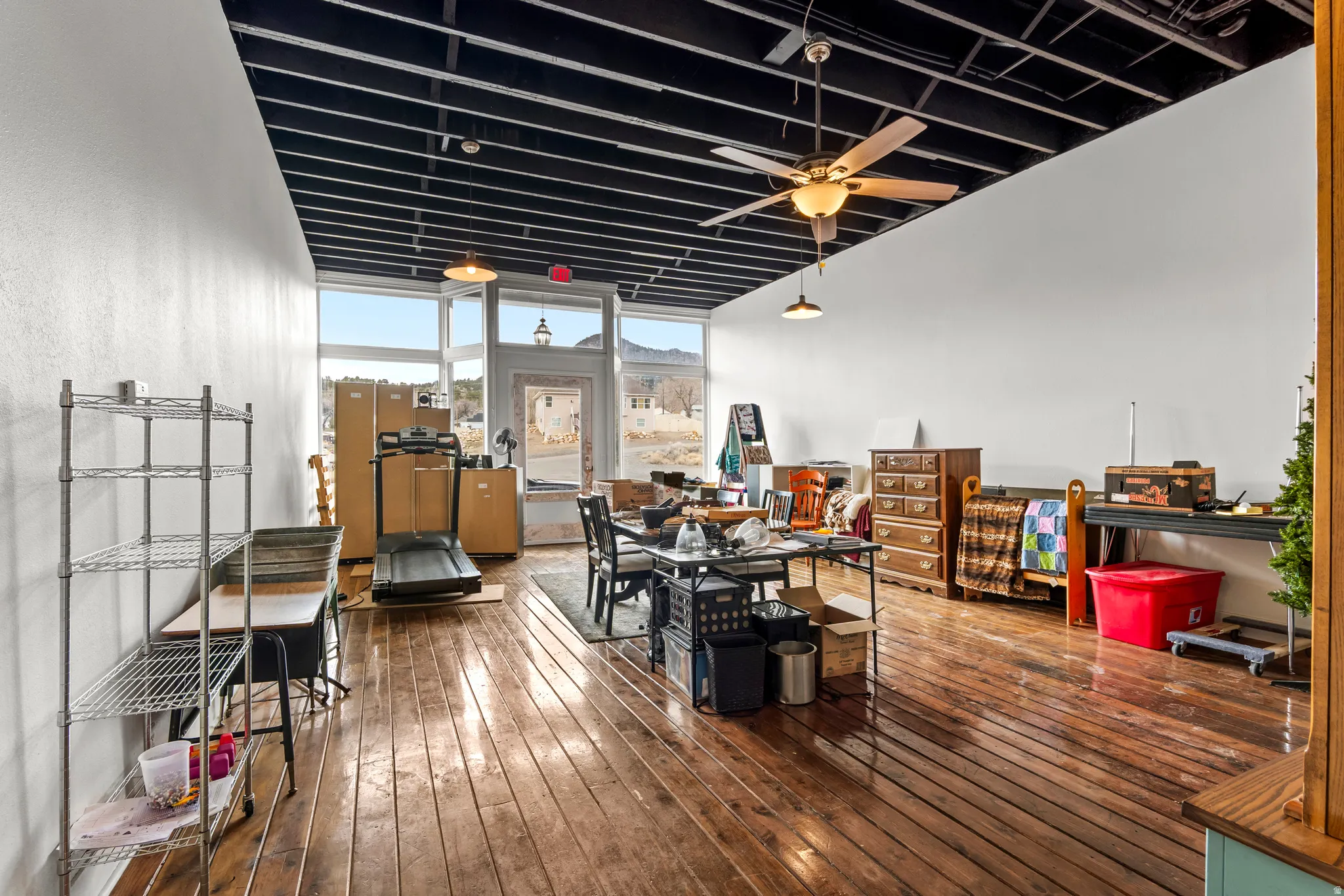 Main floor - retail / office space.   room with a ceiling fan and floor to ceiling windows