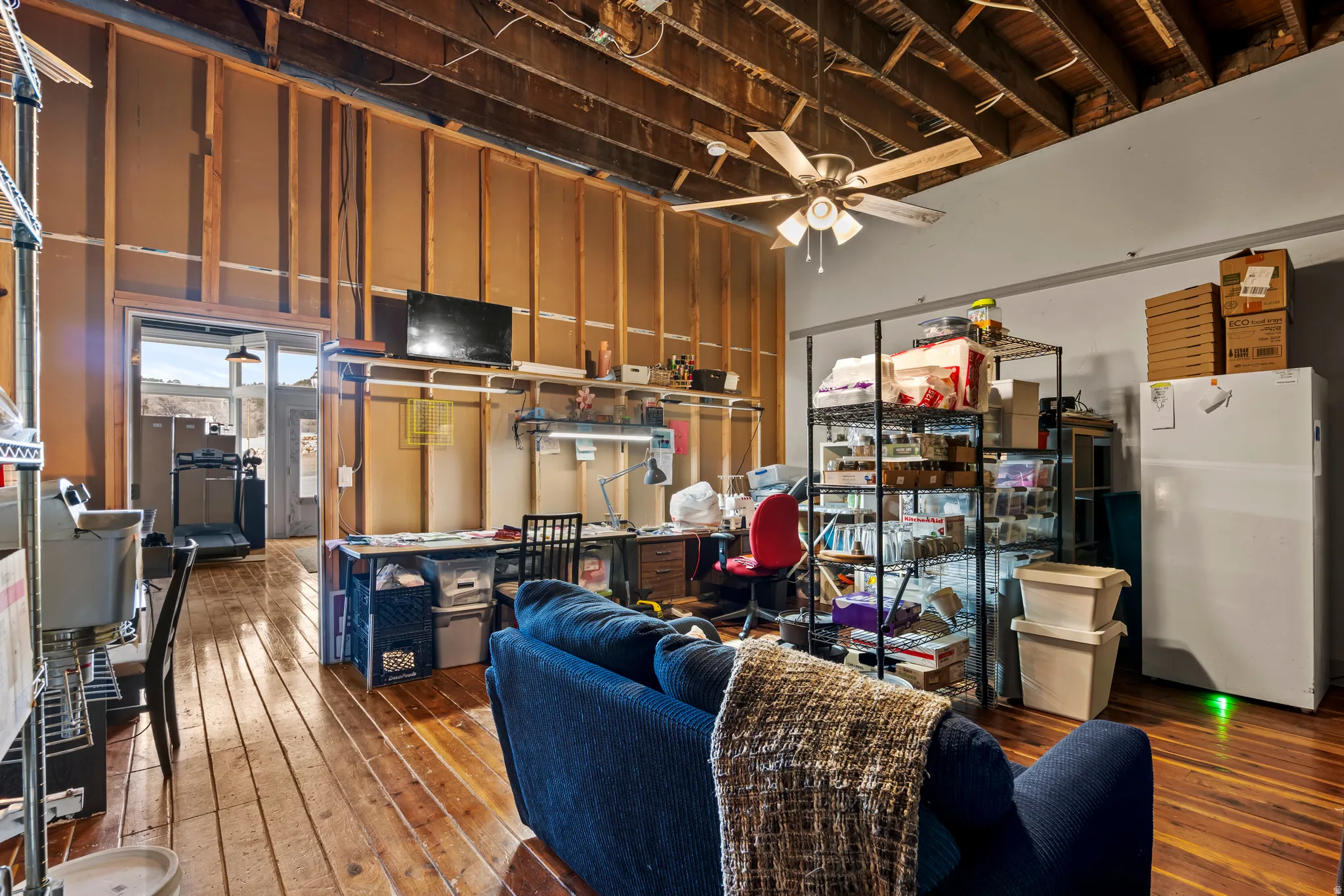 Main floor. Work area featuring ceiling fan and dark wood finished floors