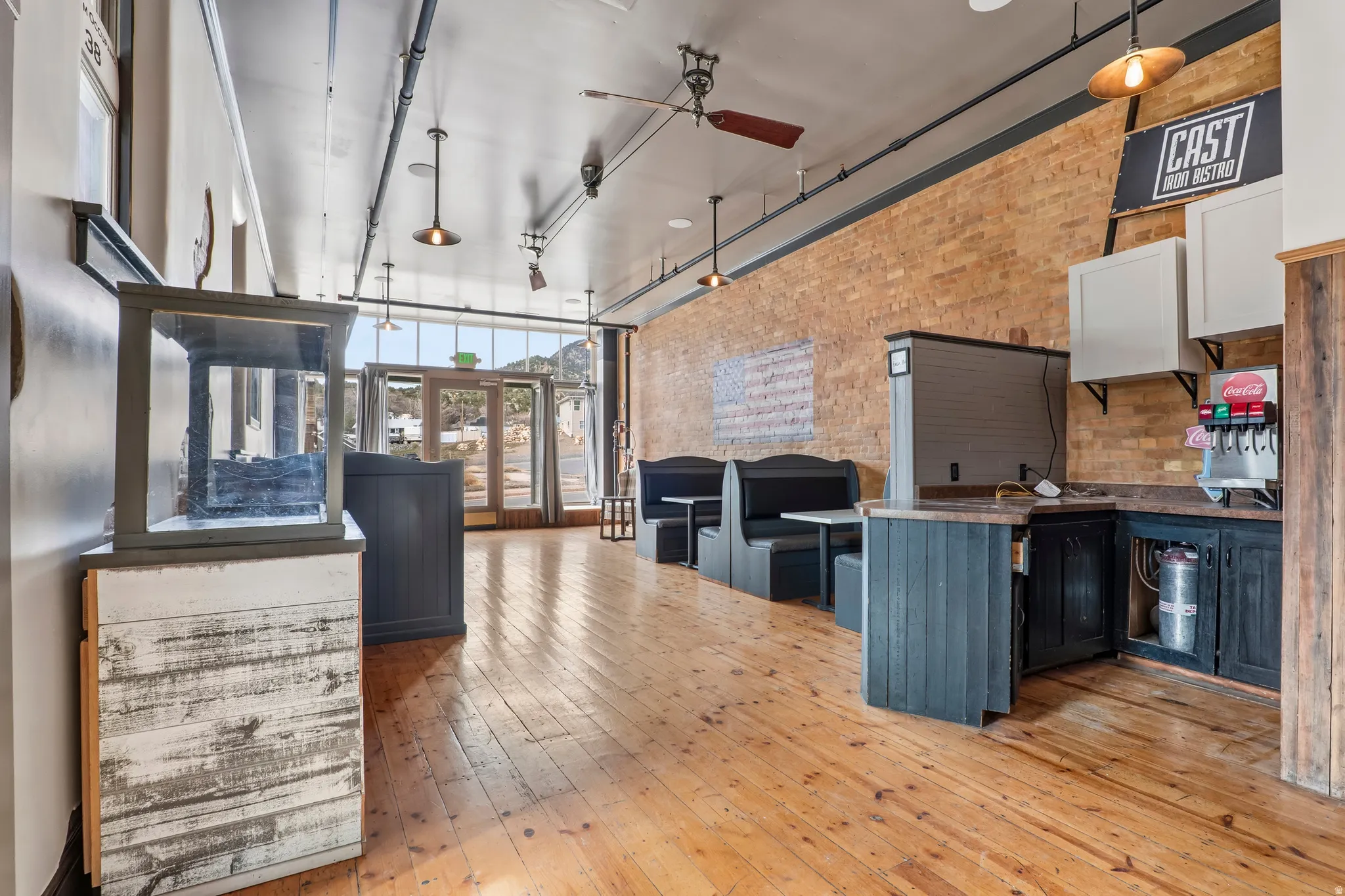 Miscellaneous room featuring brick wall, a high ceiling, a ceiling fan, and french doors