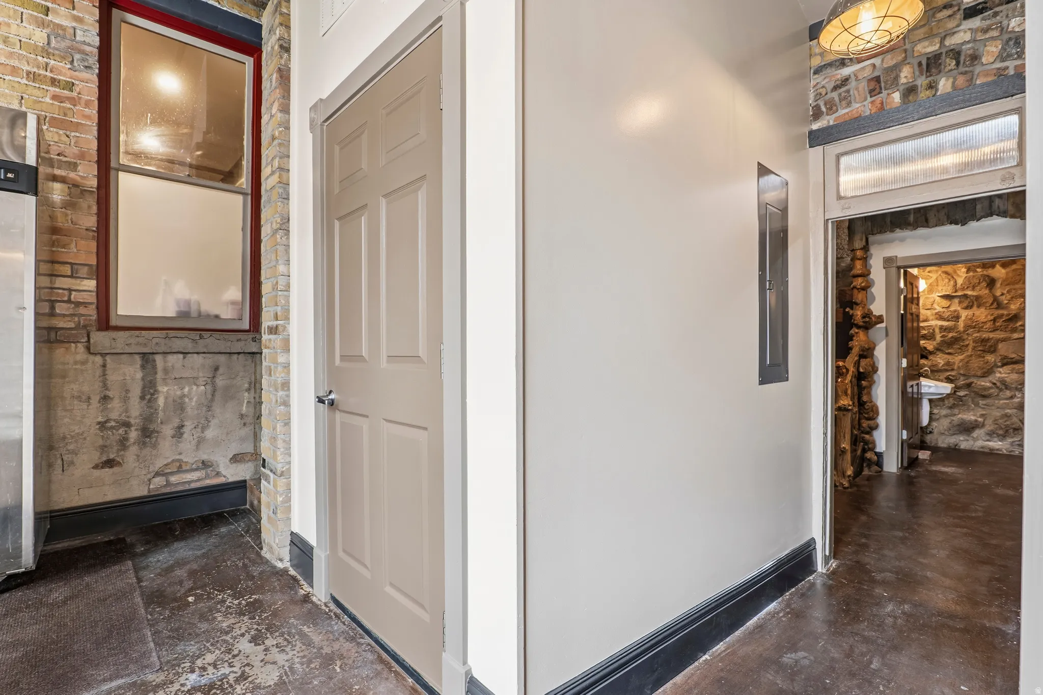 Hall featuring baseboards and finished concrete flooring