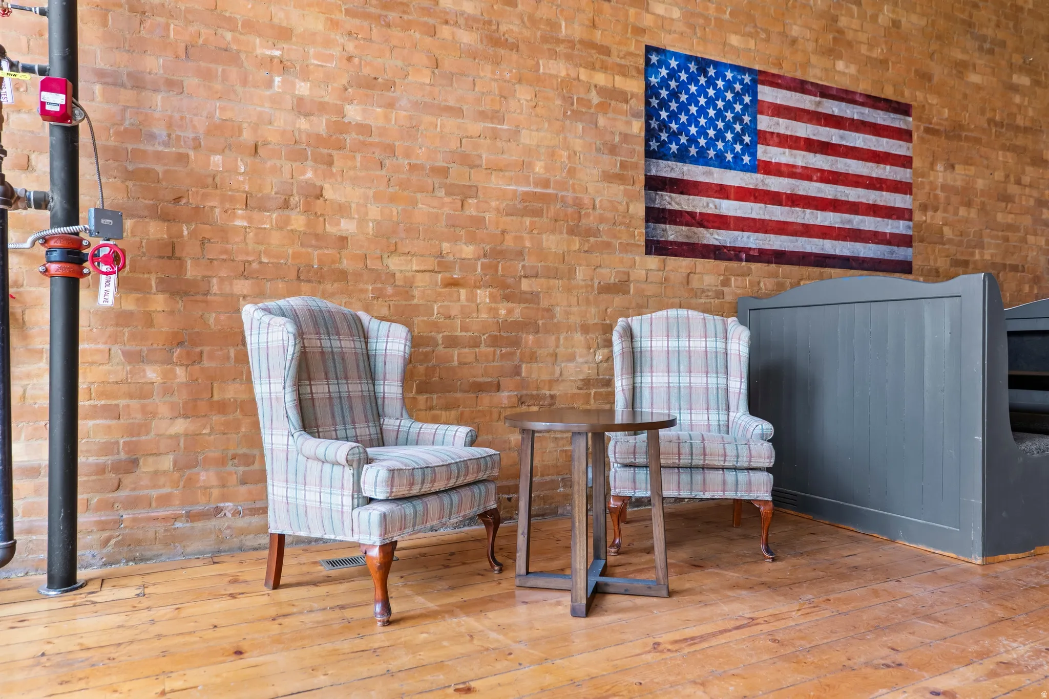 Sitting room featuring light wood finished floors and brick wall
