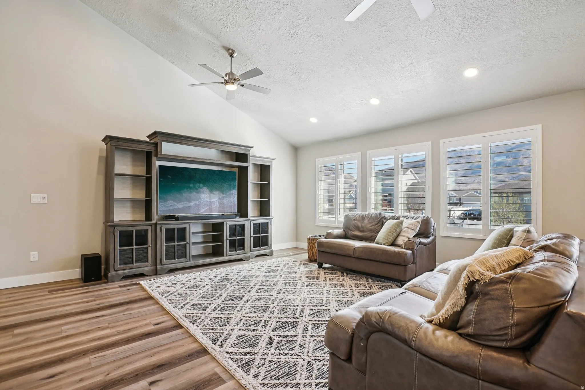 Living area with a ceiling fan, wood finished floors, and recessed lighting