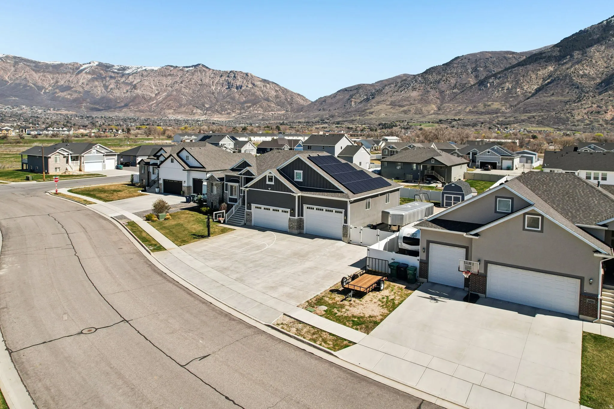 View of front of property featuring concrete driveway, a residential view, an attached garage, and a mountain view