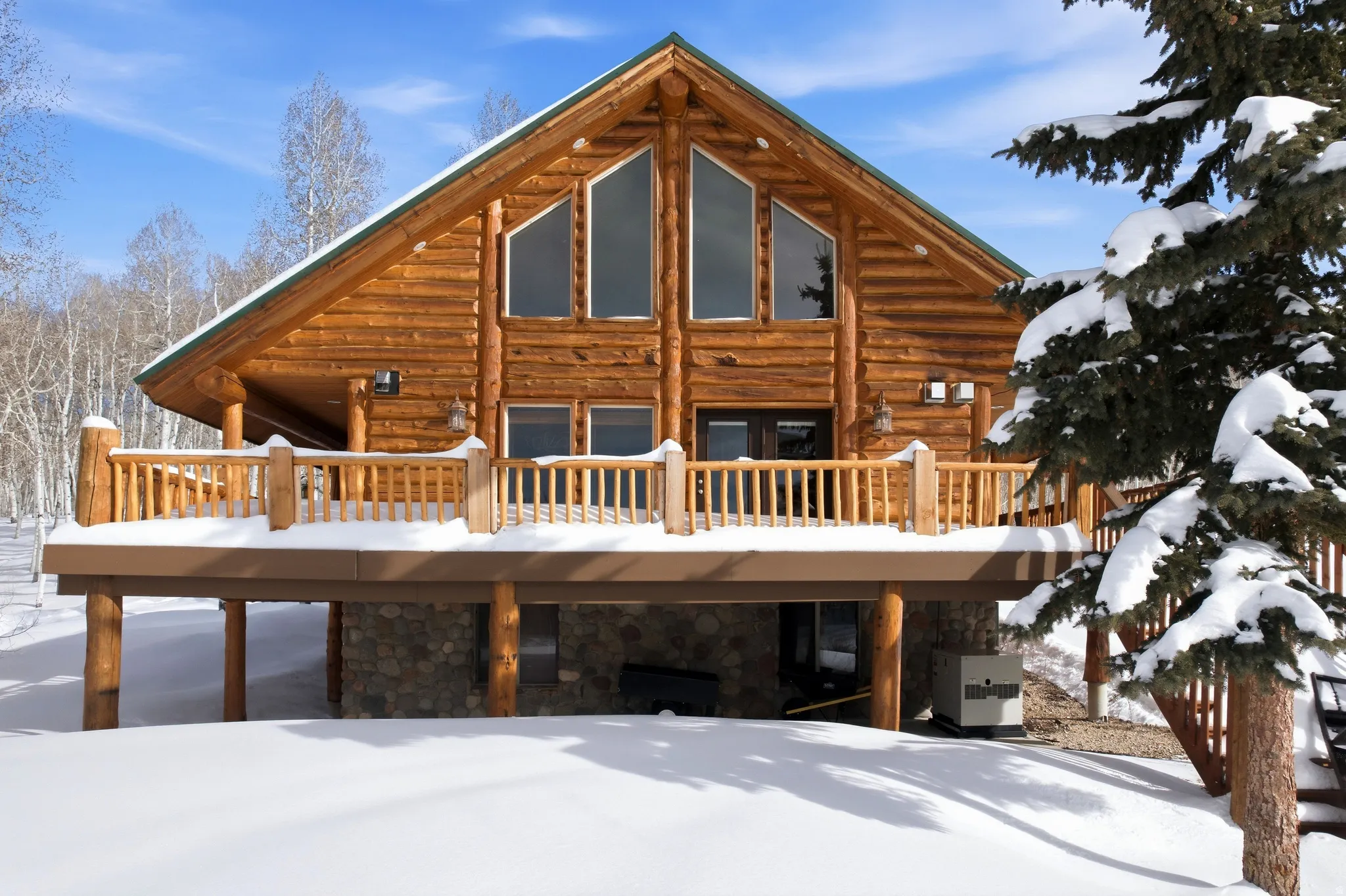 Snow covered house with stone siding