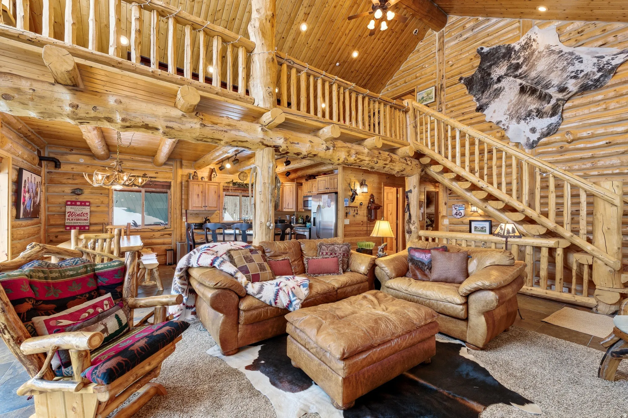 Living room featuring log walls, a high wooden beamed ceiling, ceiling fan, and recessed lighting