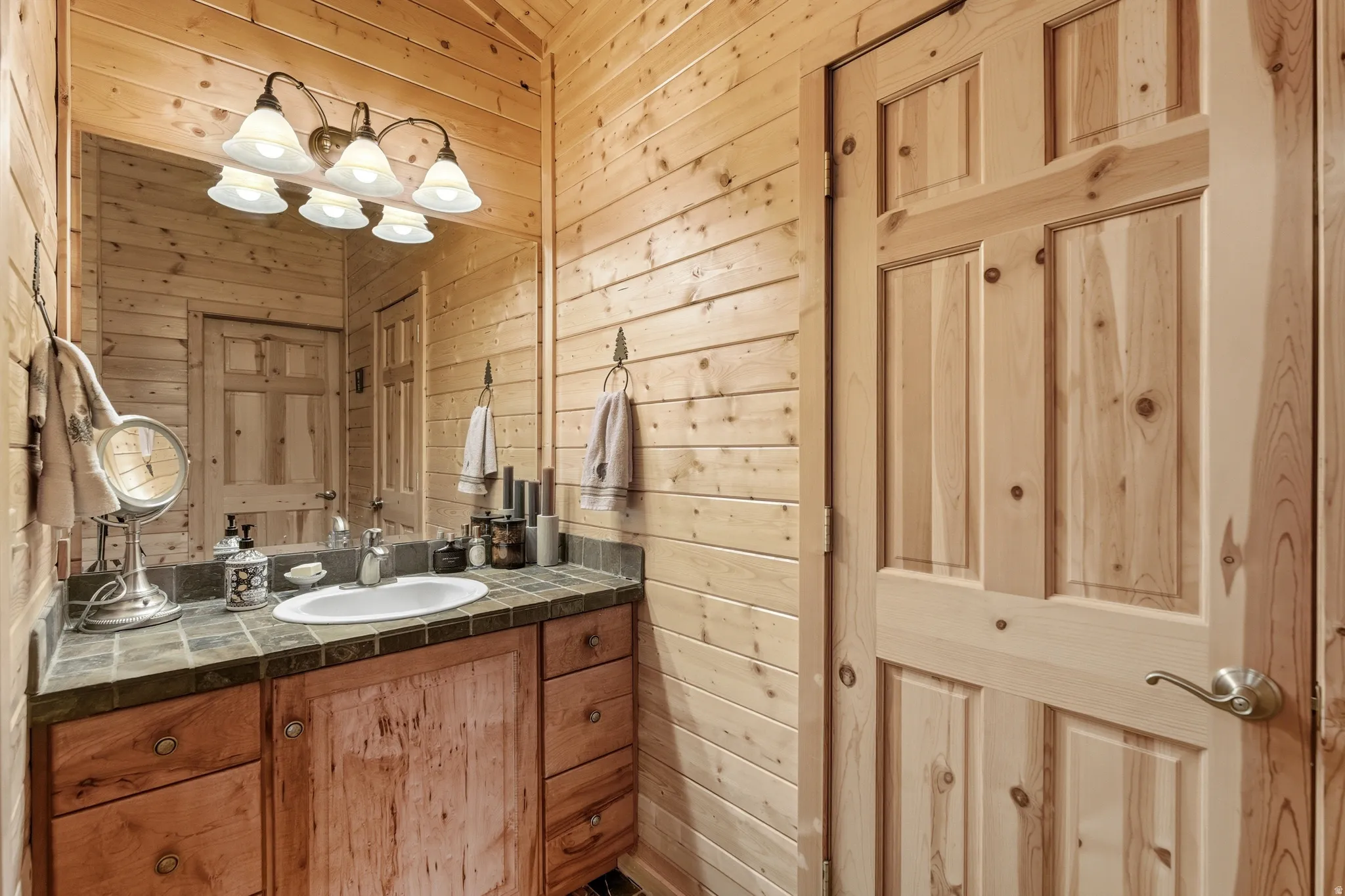 Half bath featuring wood walls and vanity