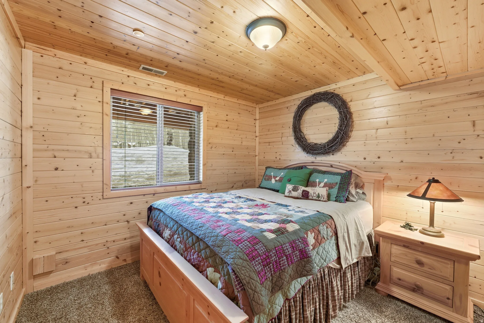 Bedroom featuring wood walls, dark carpet, and wooden ceiling