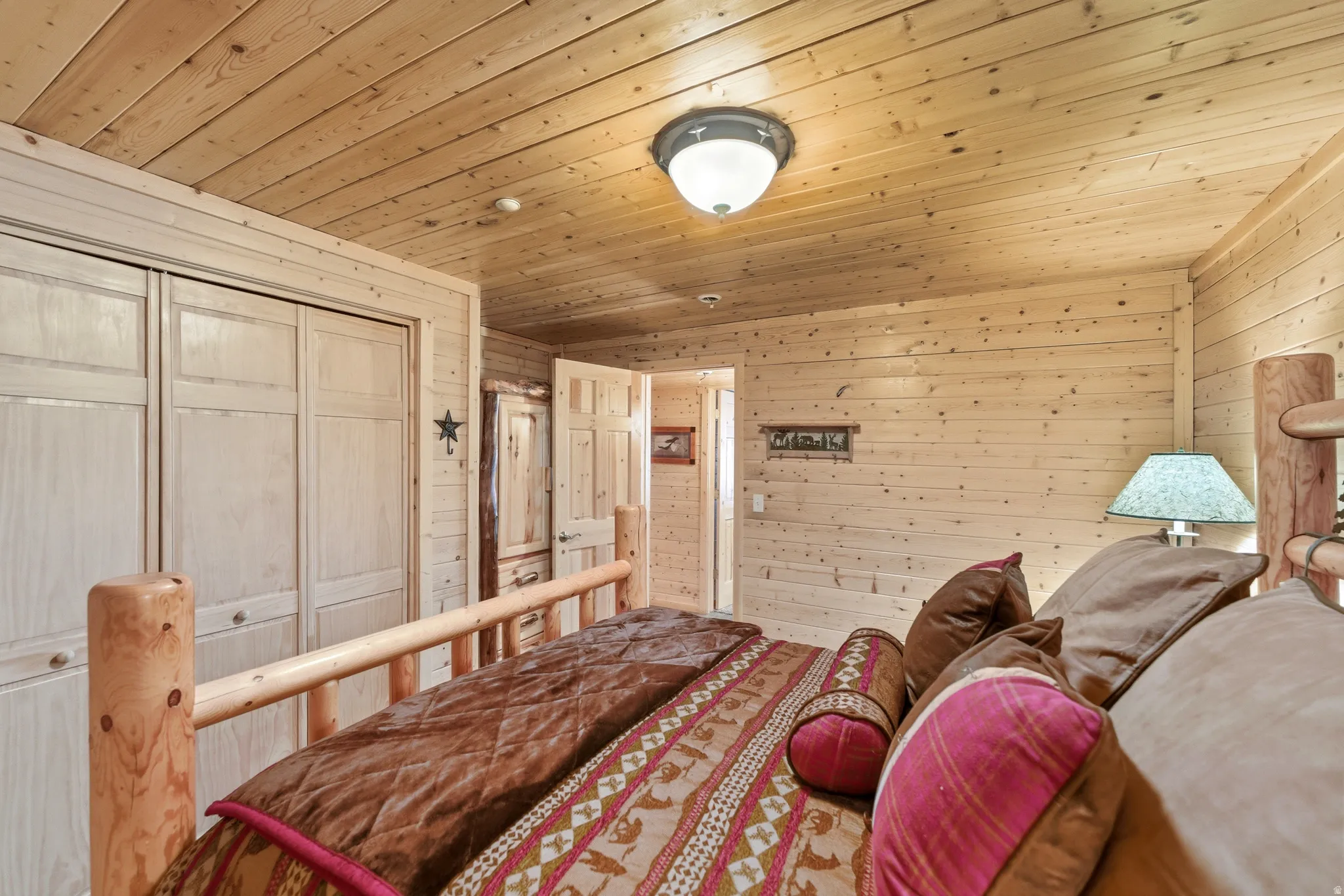 Bedroom with wood walls, a closet, and wooden ceiling