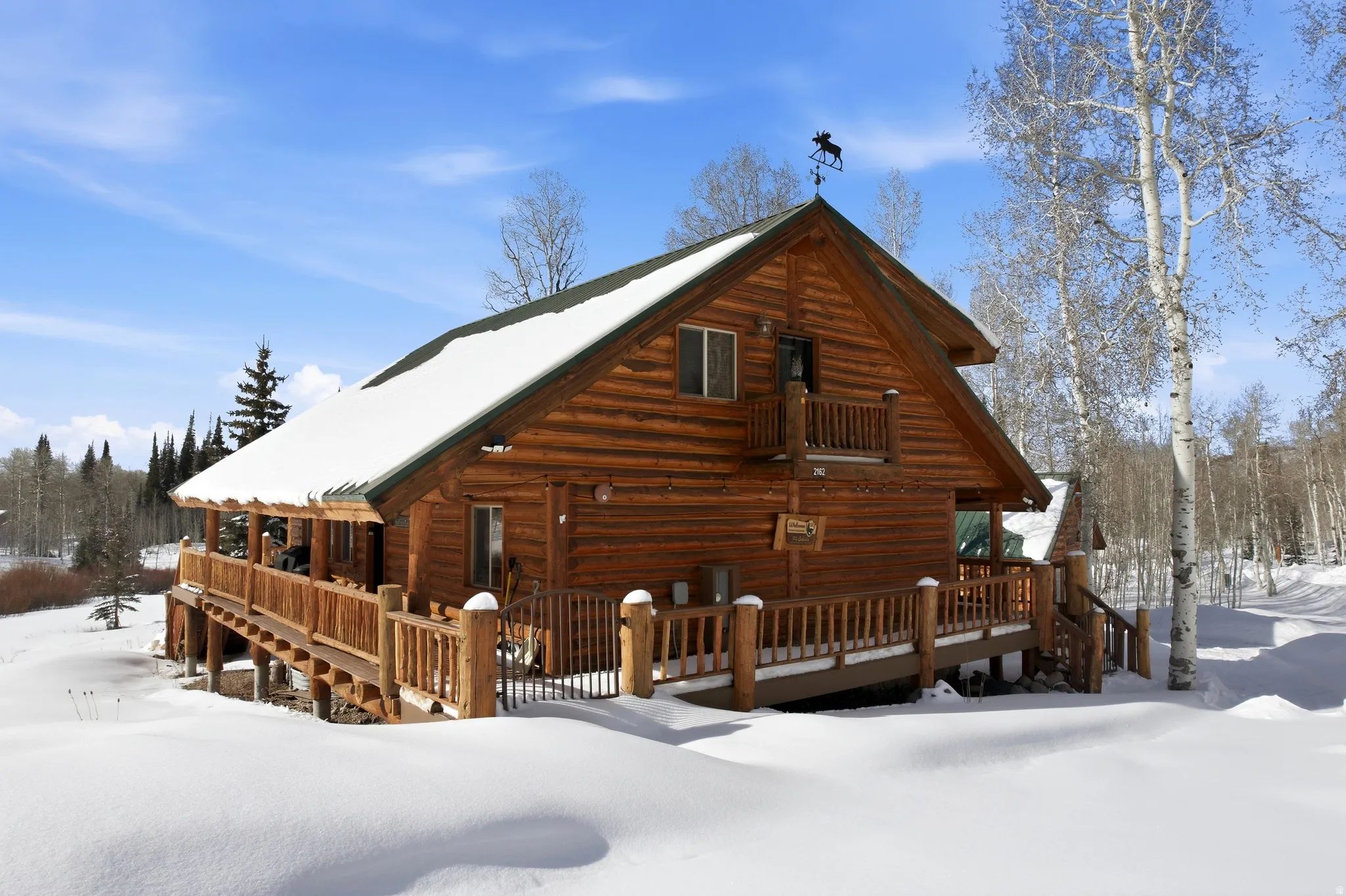 Snow covered house featuring a wooden deck