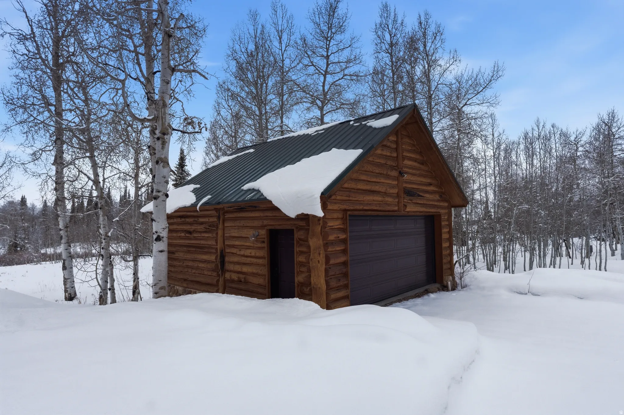 Snow covered garage featuring a garage