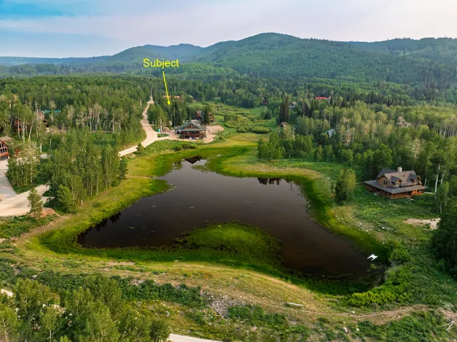 Wooded mountain setting with a large pond