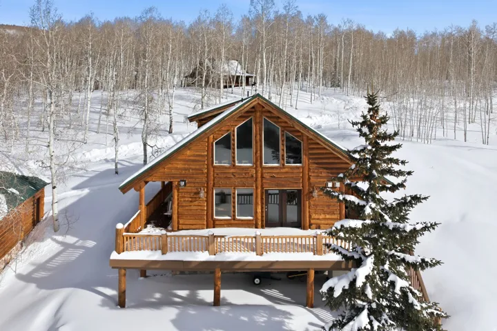 Snow covered property with a deck