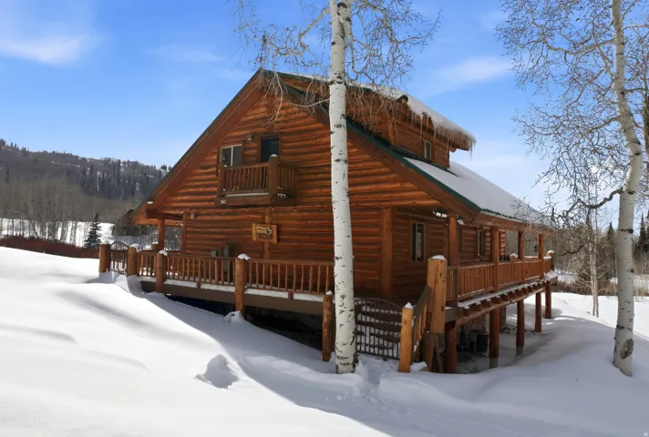 View of snowy exterior with a porch