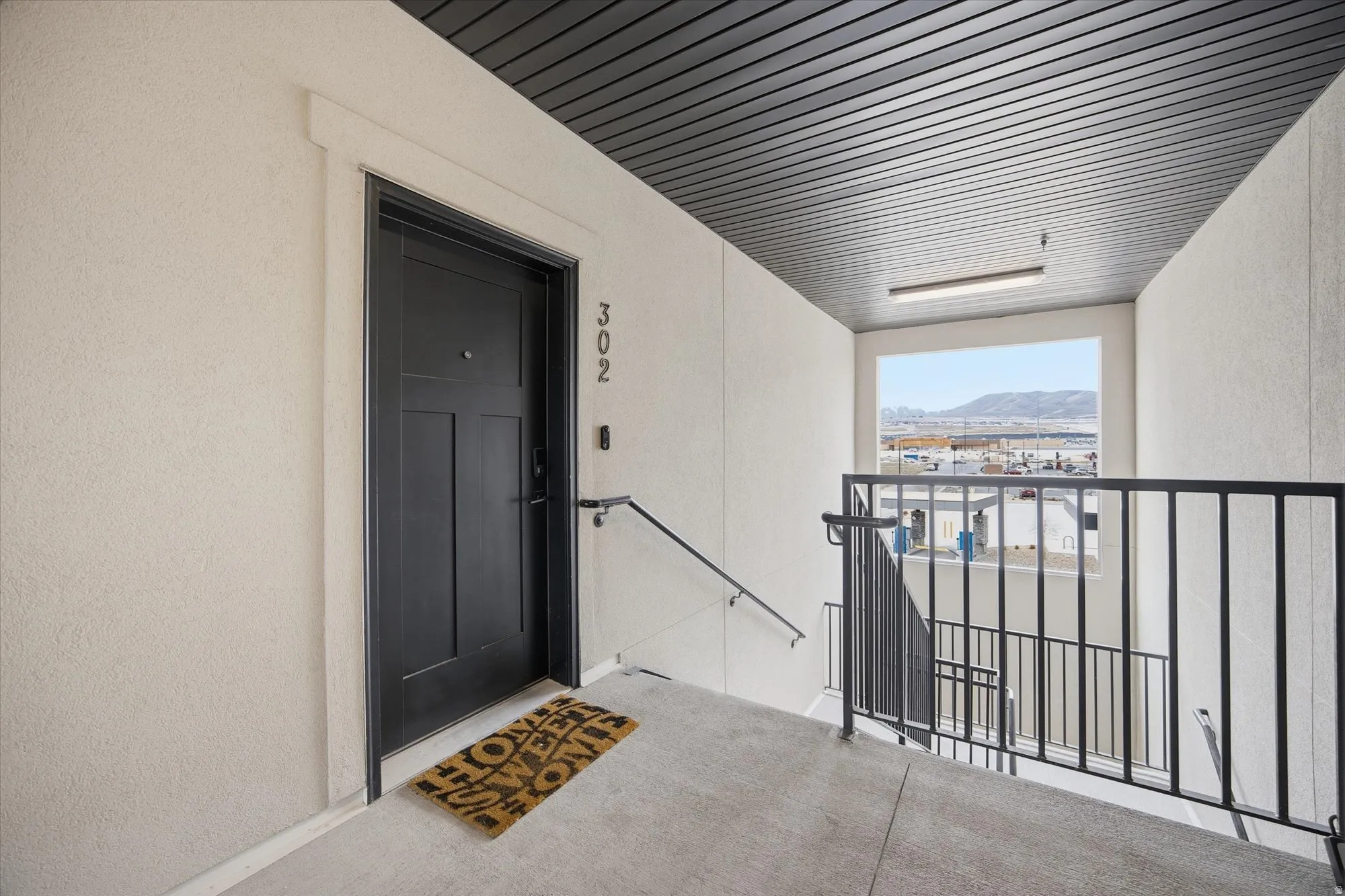 Doorway to property with a mountain view, stucco siding, and a patio area