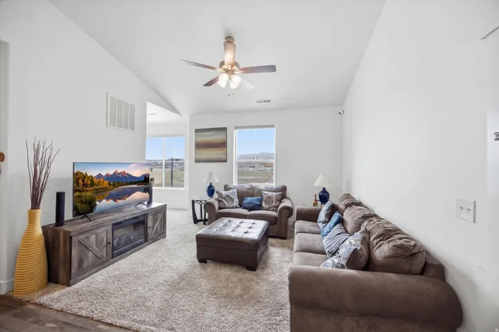 Living room featuring a ceiling fan and vaulted ceiling