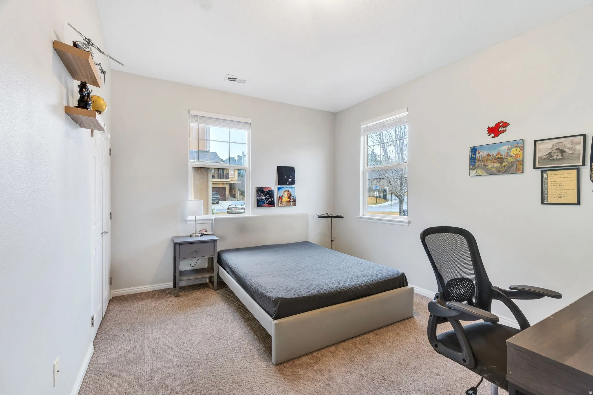 Large windows allow abundant natural light in this corner bedroom