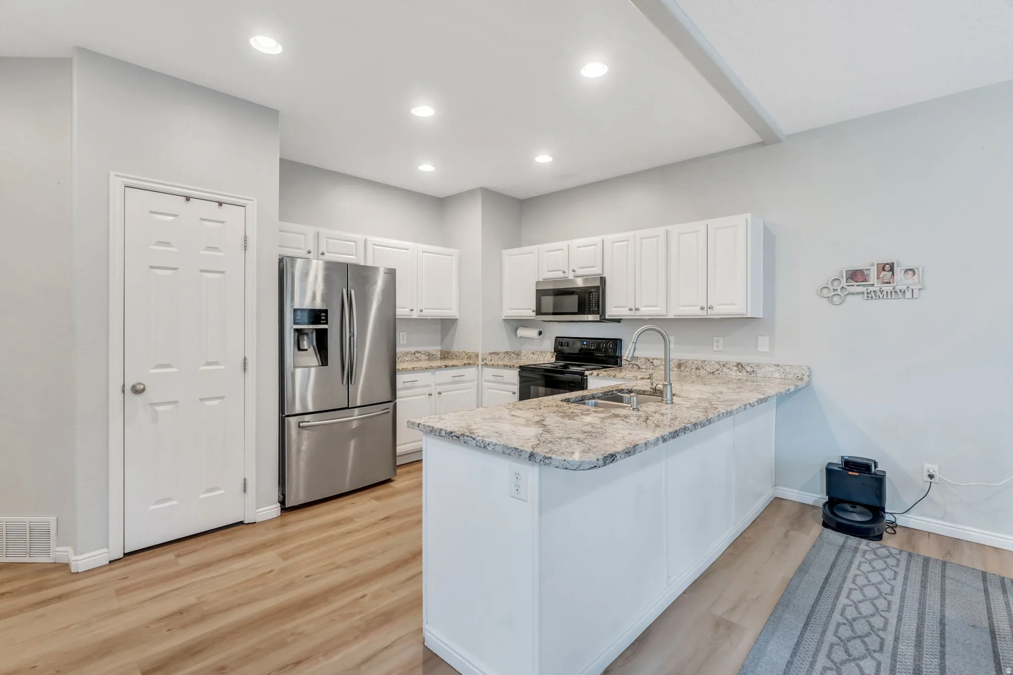 Large granite breakfast bar is a great place to gather