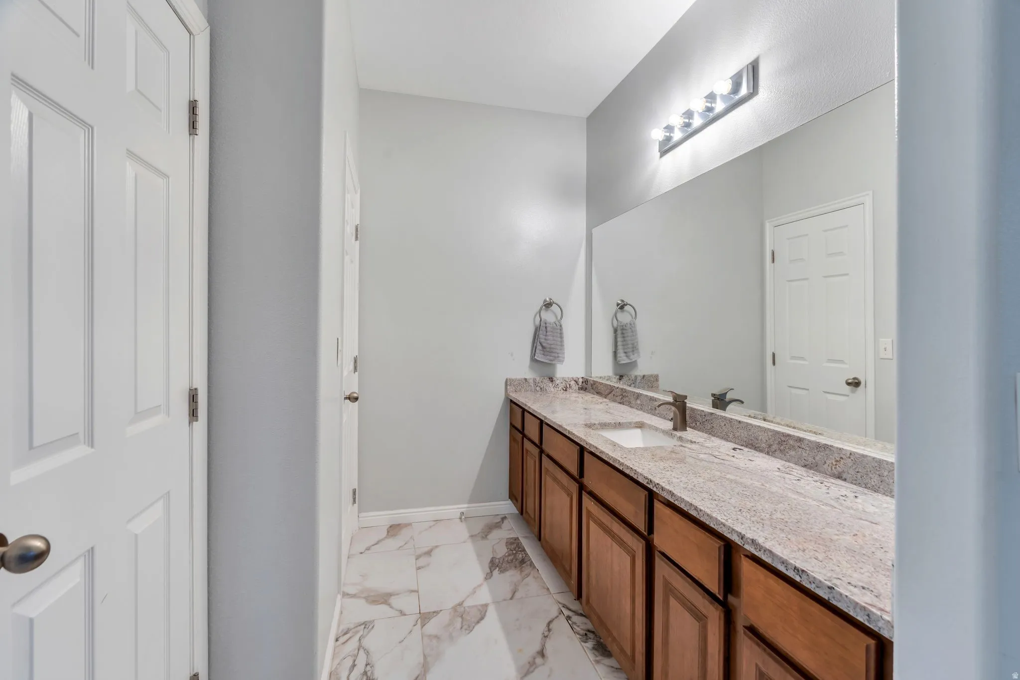 Large granite vanity and warm cabinetry