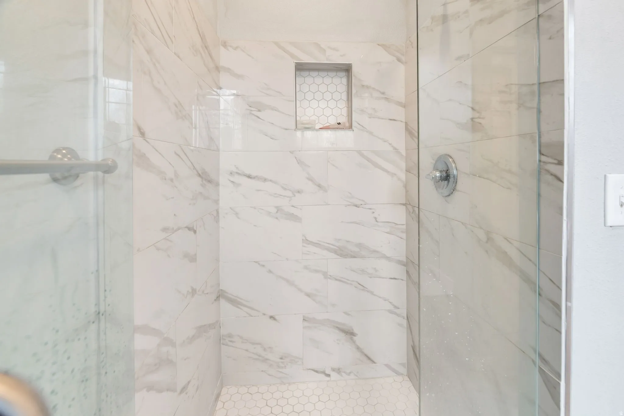 Full bathroom with a marble finish shower