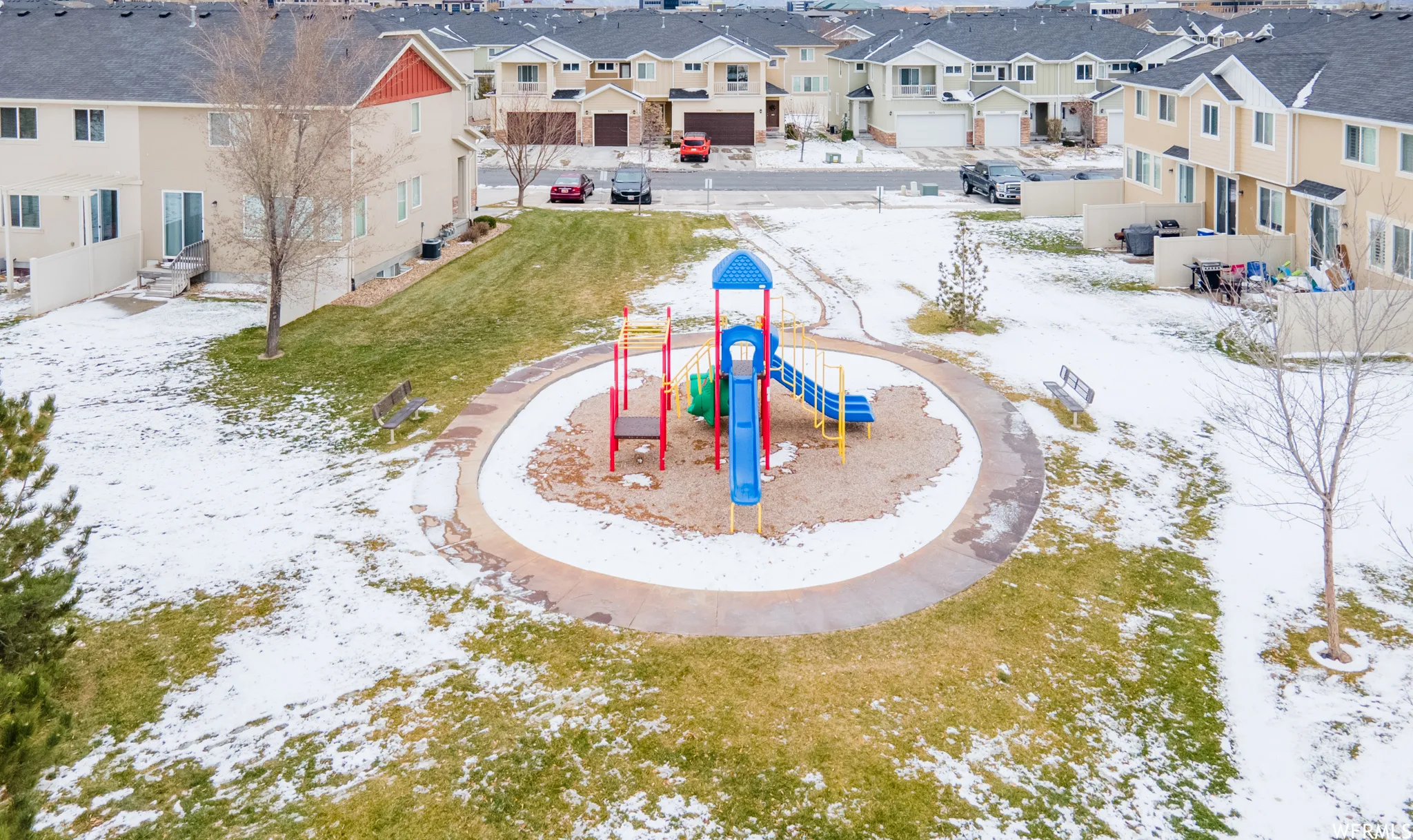 Snowy aerial view with a view of greenspace and a residential view