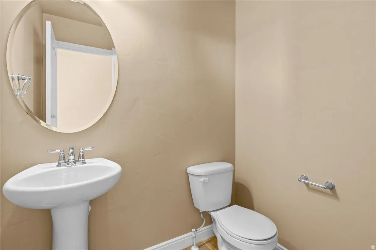 Half bathroom with toilet and baseboards