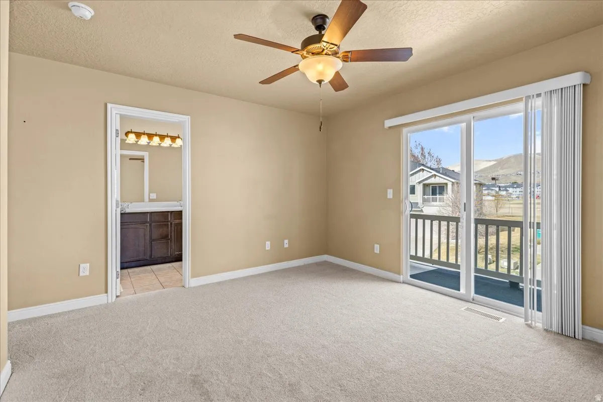 Spare room with ceiling fan, light colored carpet, a textured ceiling, a smoke detector, and a mountain view