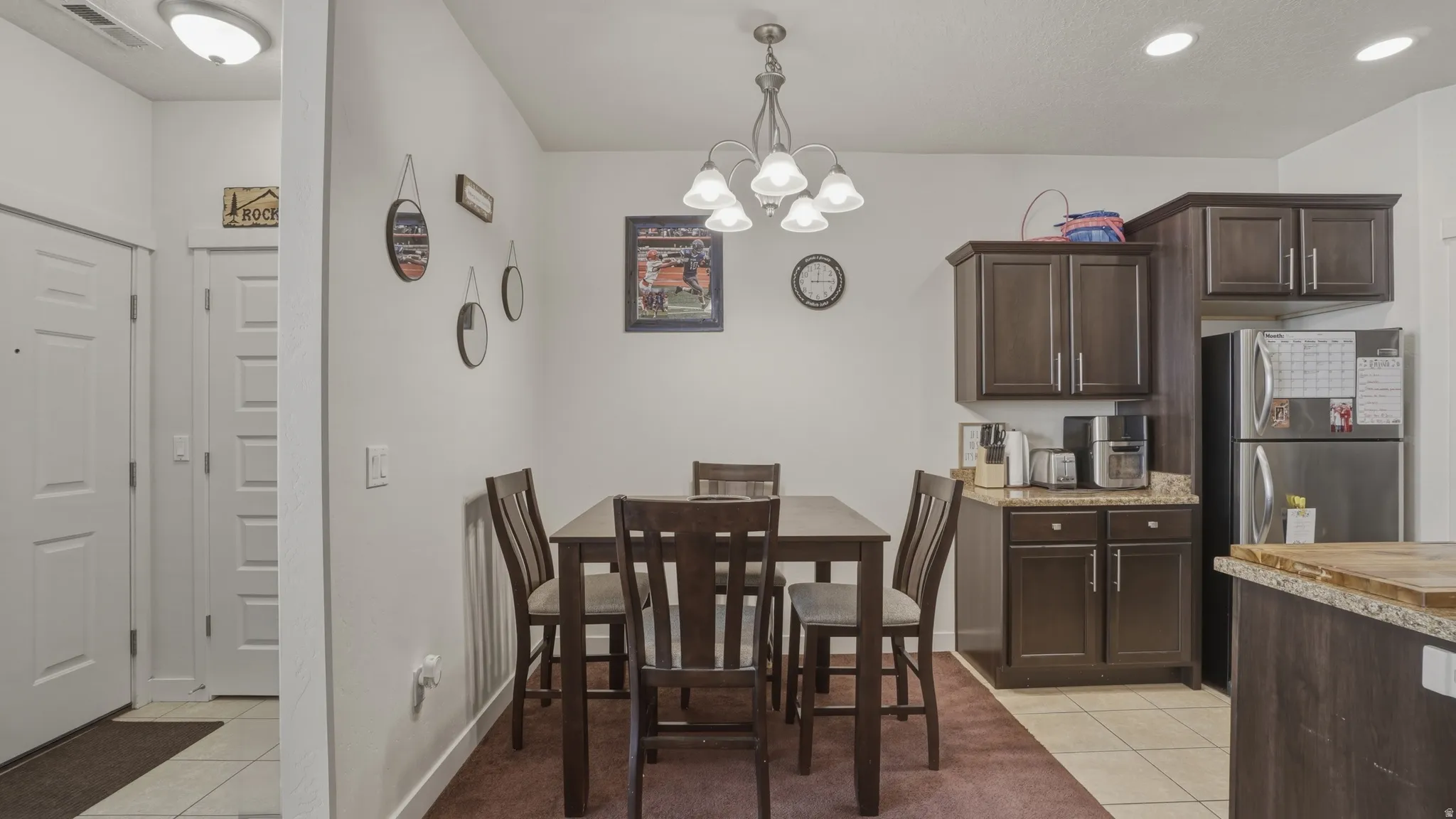 Dining space featuring light tile patterned floors and a chandelier