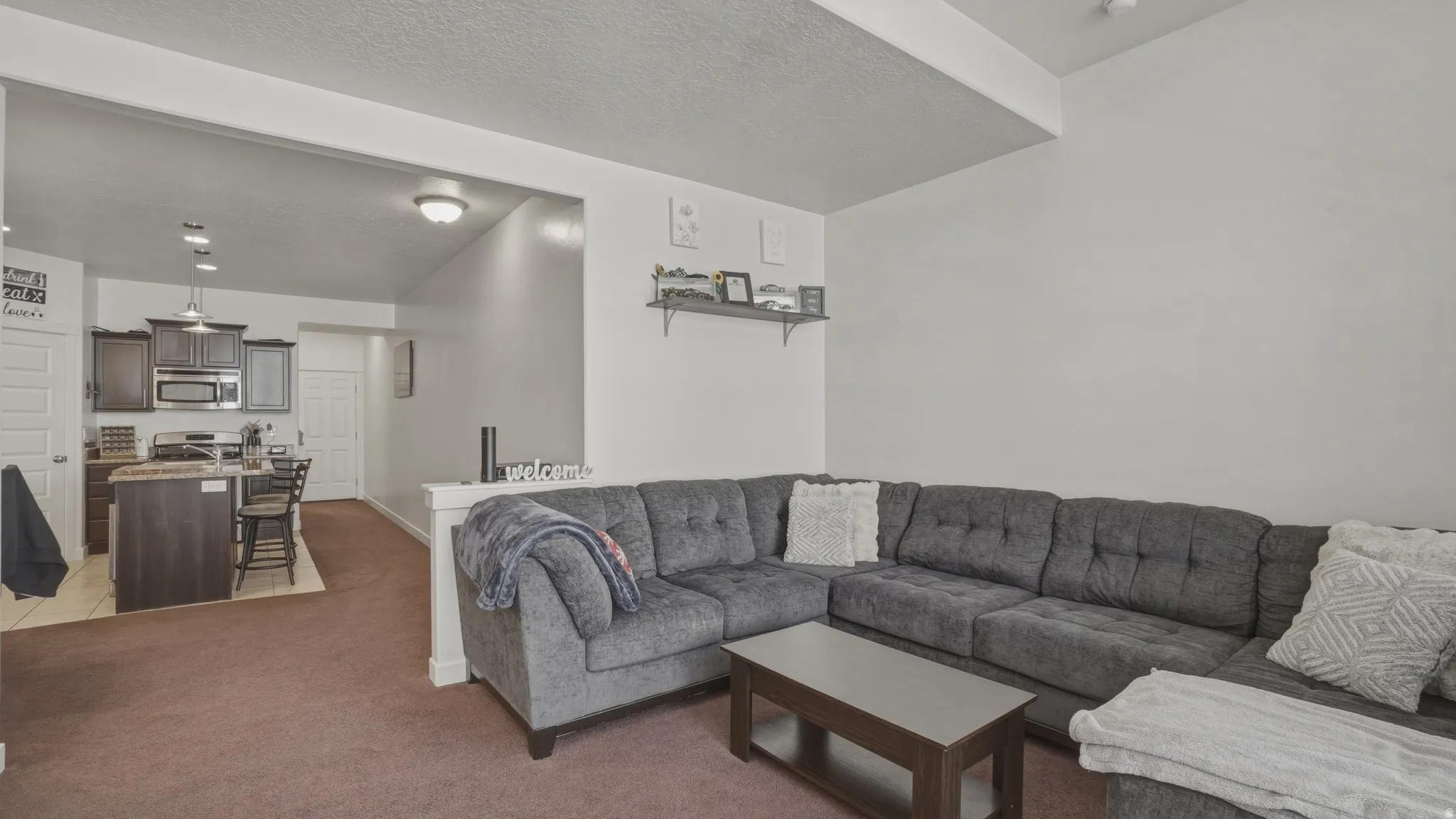 Living area featuring light carpet and a textured ceiling