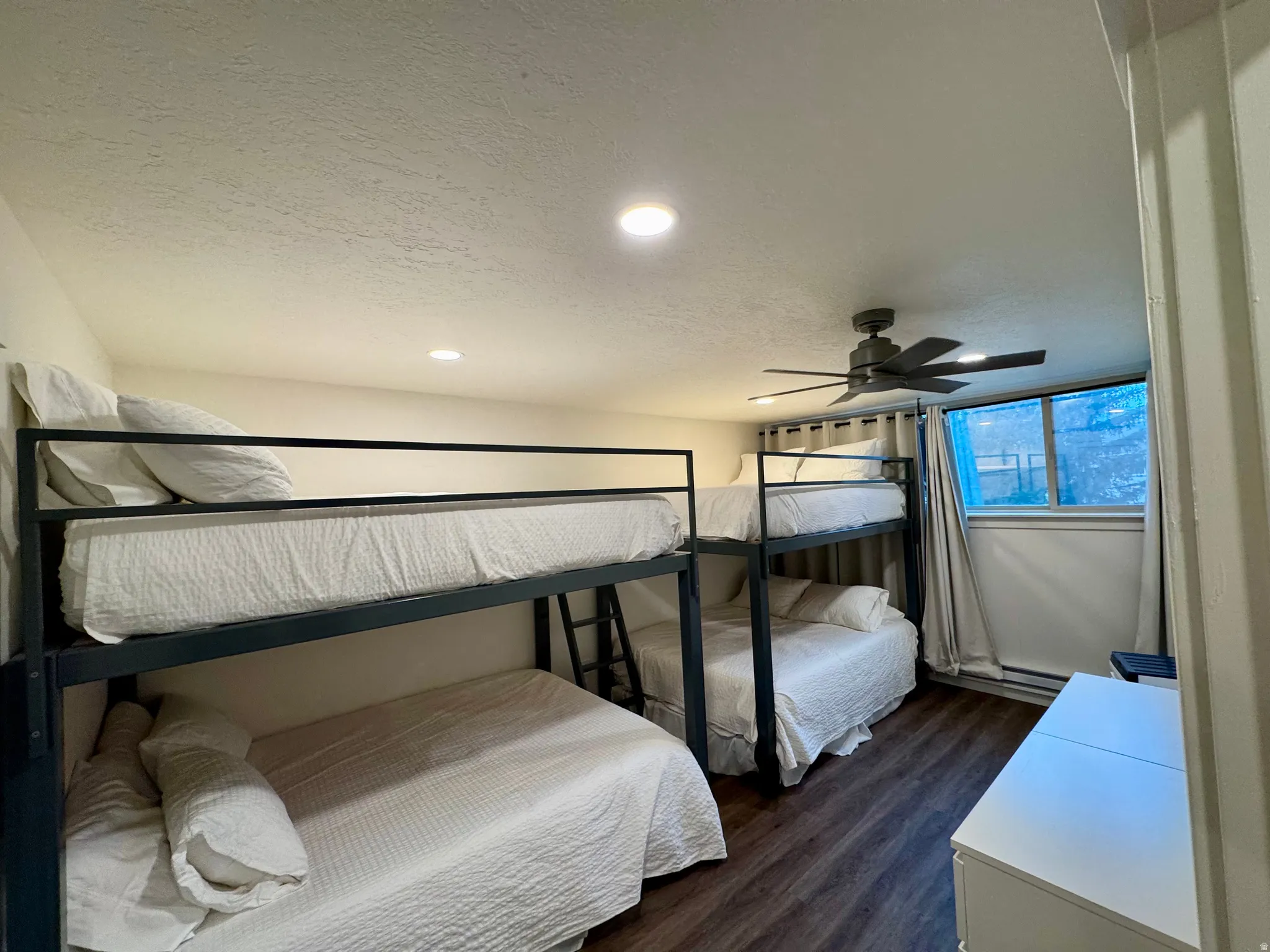 Bedroom with a textured ceiling, dark wood-style flooring, recessed lighting, a ceiling fan, and a baseboard heating unit