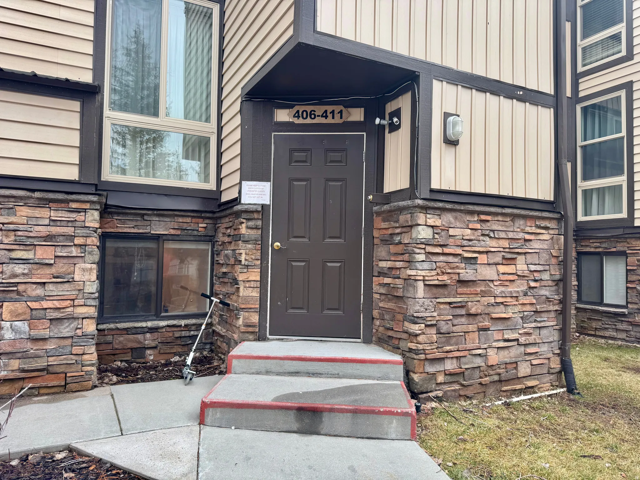 View of exterior entry featuring stone siding and board and batten siding
