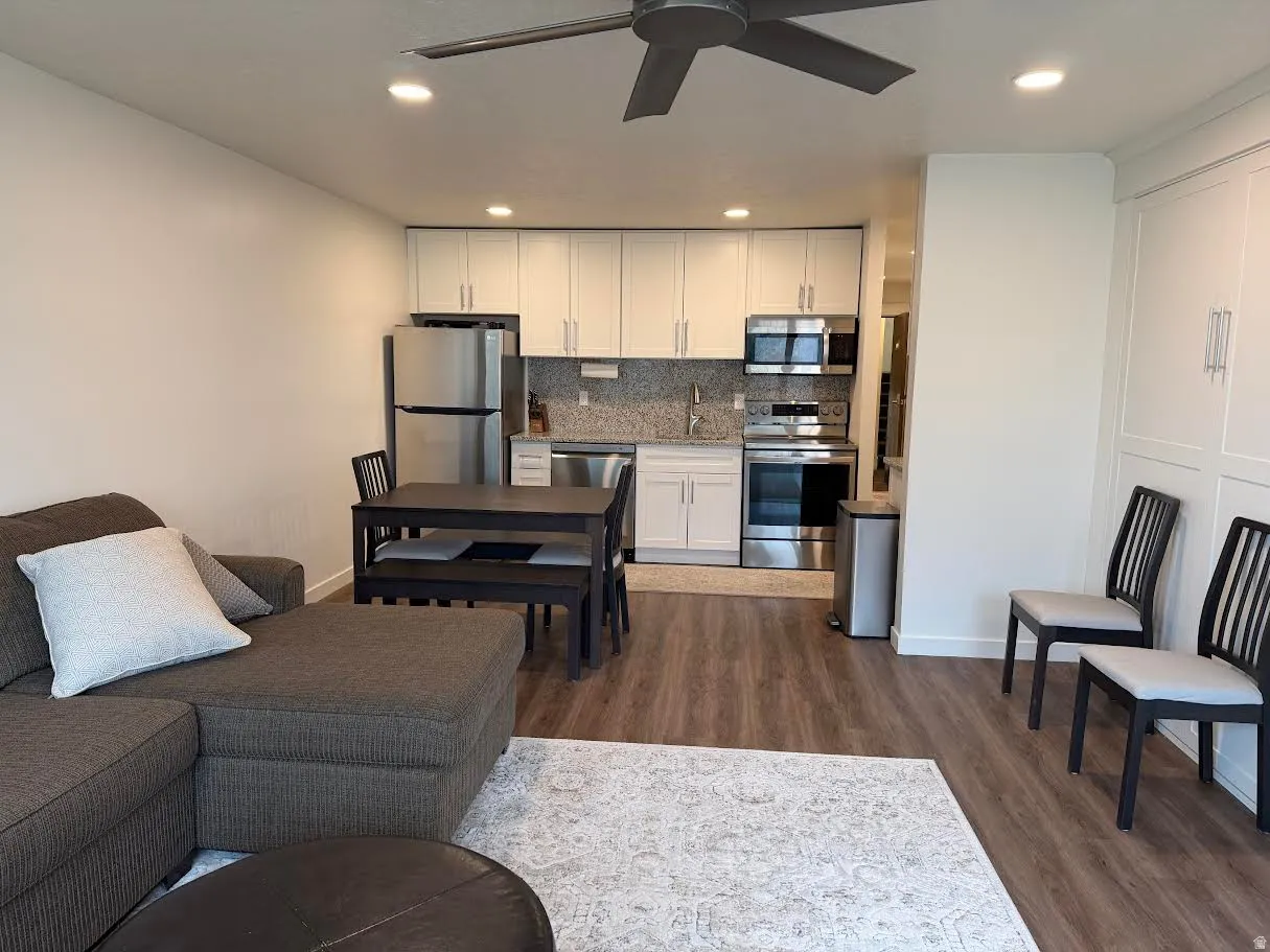Living room featuring a ceiling fan, dark wood-style floors, and recessed lighting
