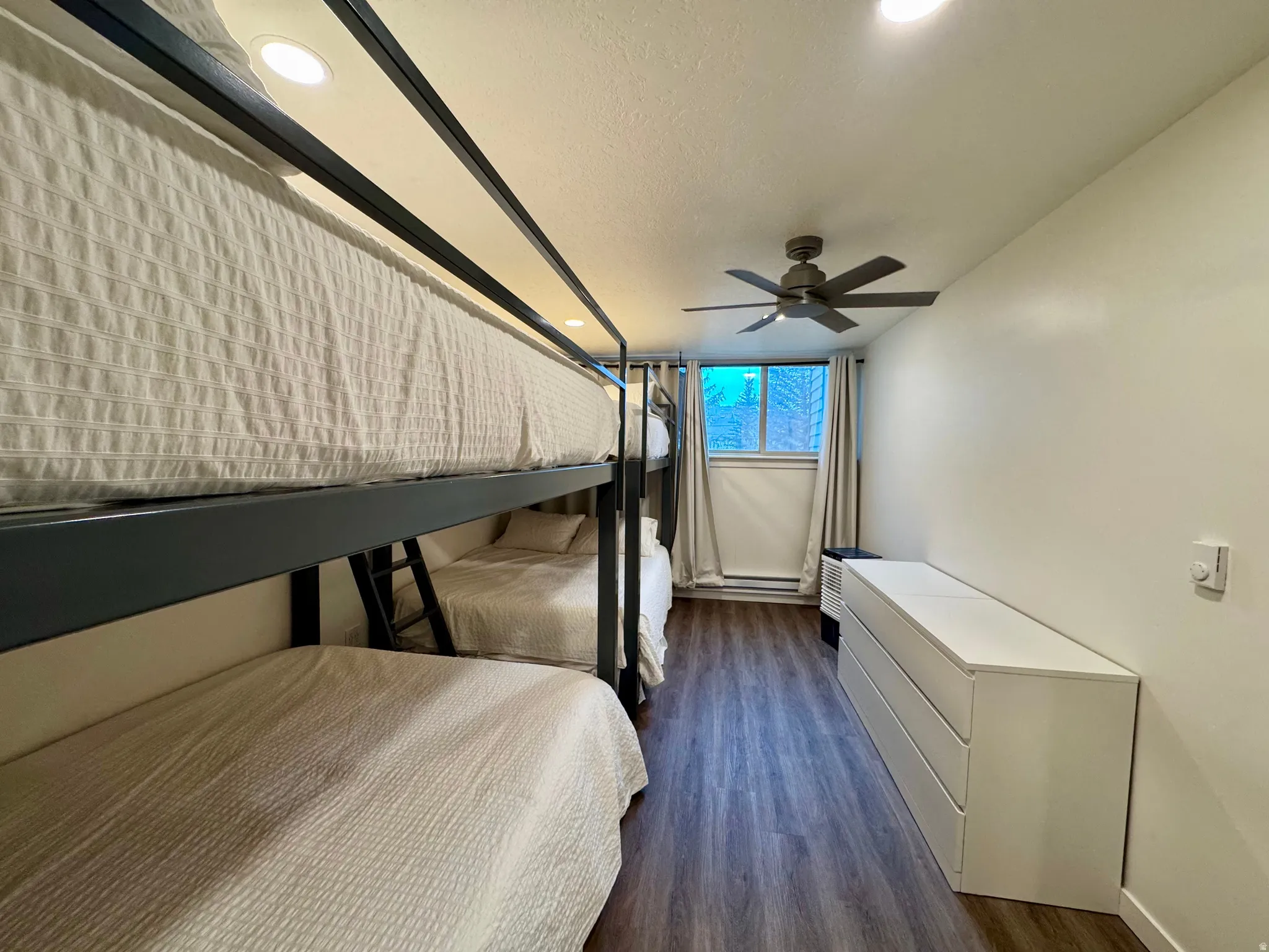Bedroom with dark wood-type flooring, recessed lighting, and a textured ceiling