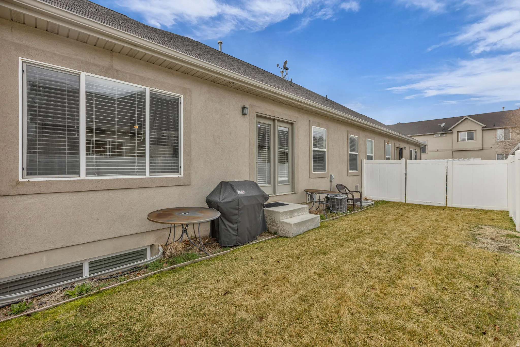 Back of property featuring stucco siding, a patio area, and roof with shingles
