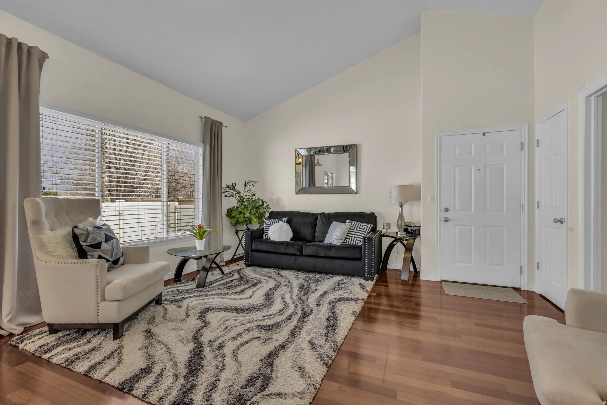 Living area with dark wood-style floors and vaulted ceiling
