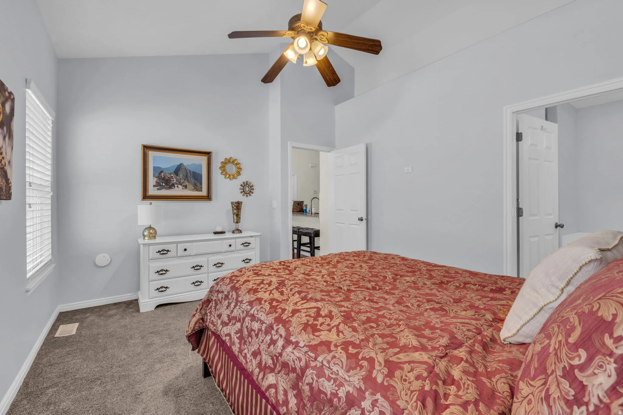 Bedroom with dark carpet, lofted ceiling, and ceiling fan