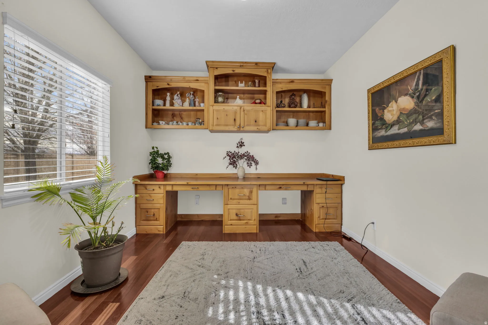 Office space featuring built in desk and dark wood finished floors