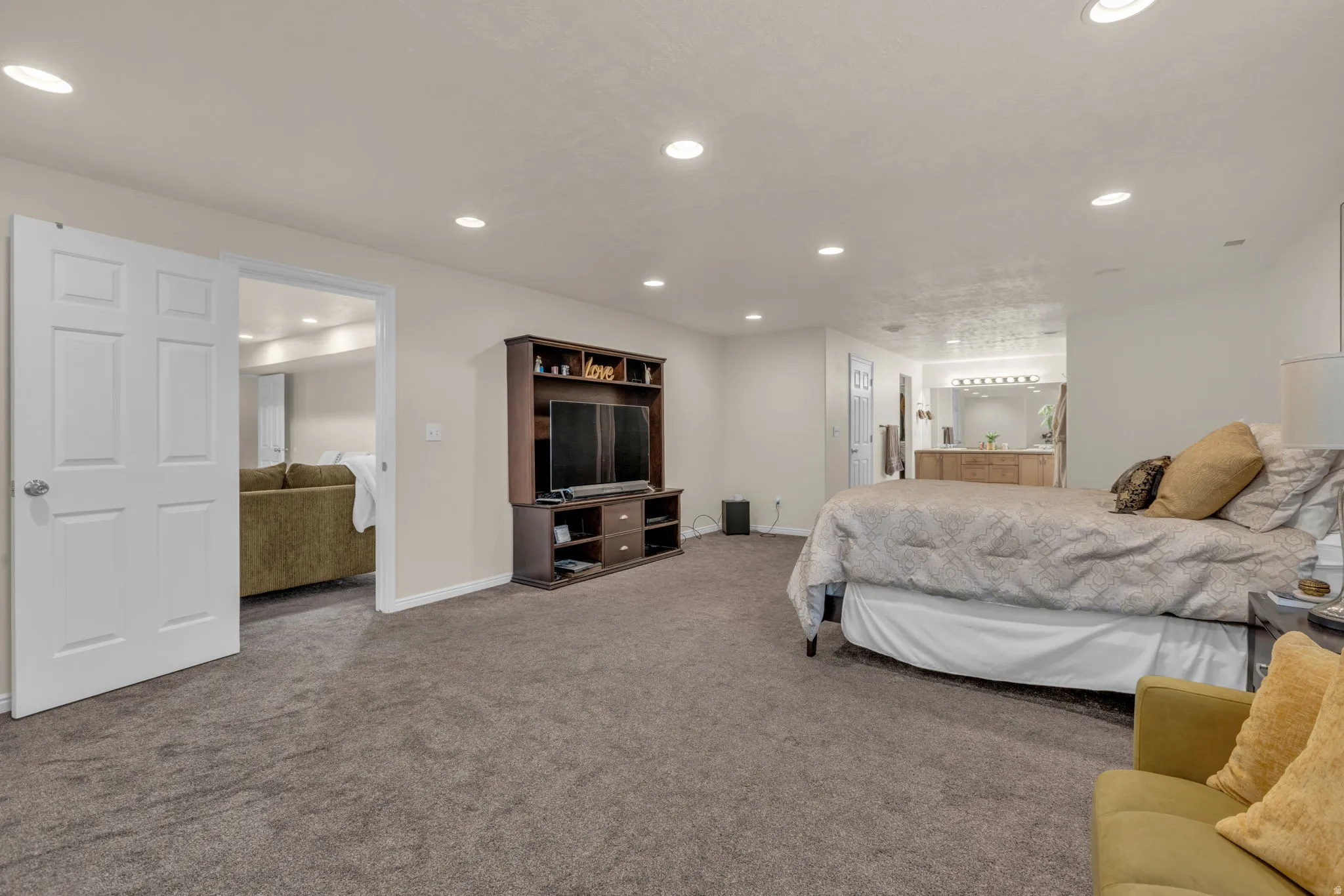 Carpeted bedroom featuring recessed lighting and ensuite bathroom