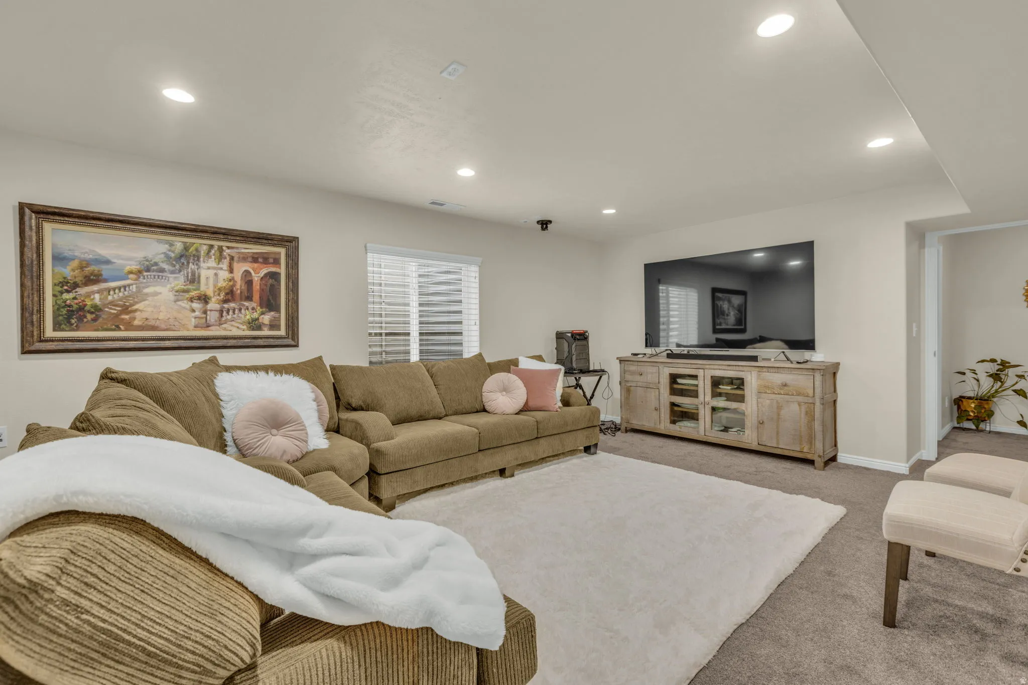 Living area featuring light colored carpet and recessed lighting