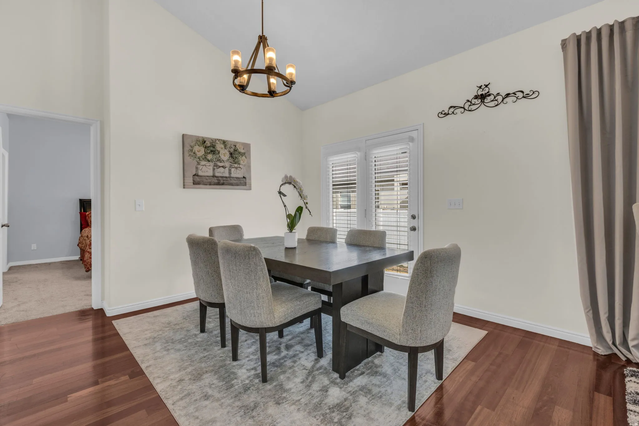 Dining area with lofted ceiling, hanging lights, and wood finished floors