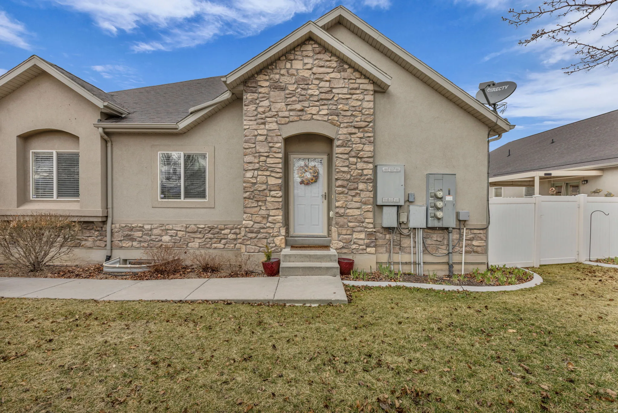 View of front of house with stone siding, stucco siding, and entry steps