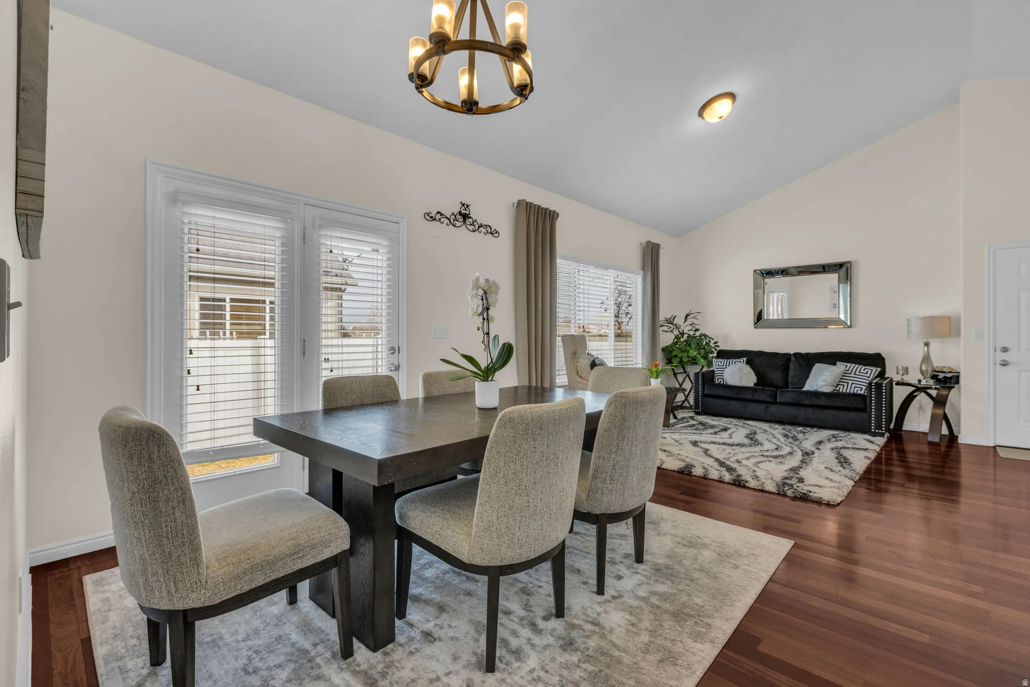 Dining space featuring dark wood-type flooring, suspended lighting, and vaulted ceiling