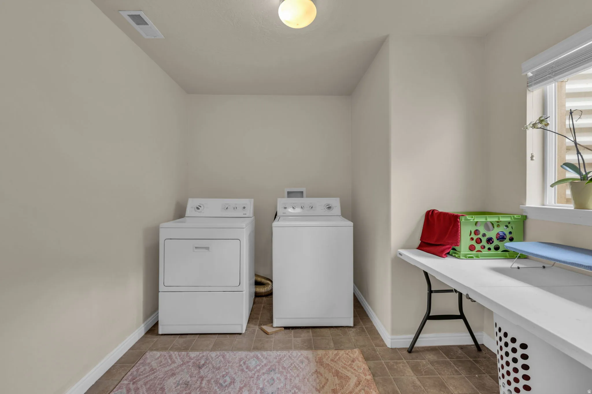 Laundry area with baseboards and washer and clothes dryer