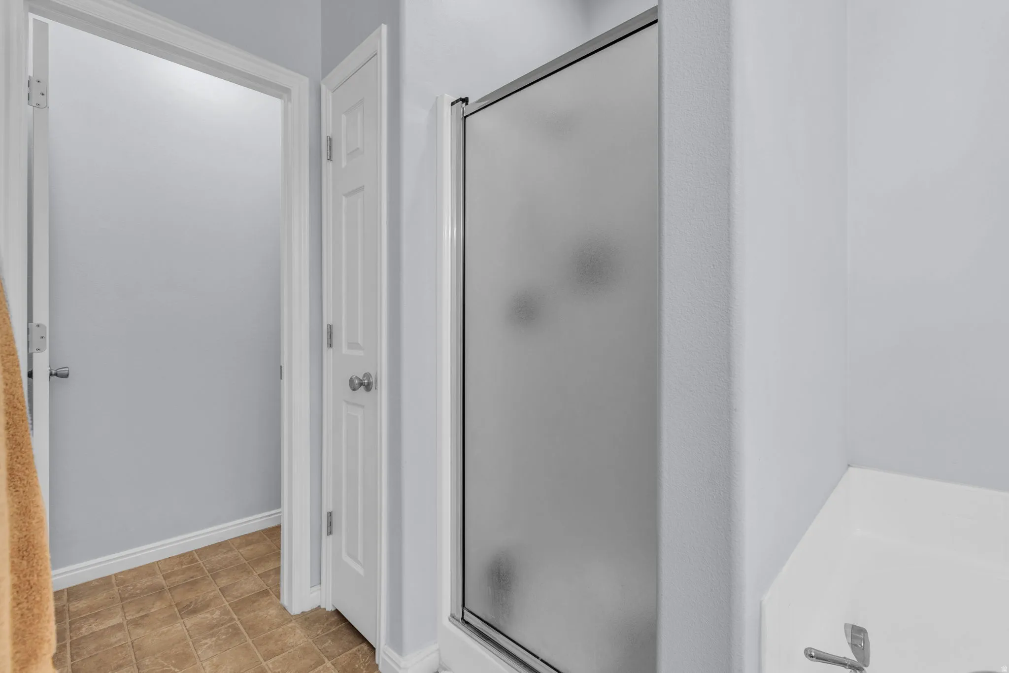 Bathroom with a bath, a shower stall, and stone finish flooring
