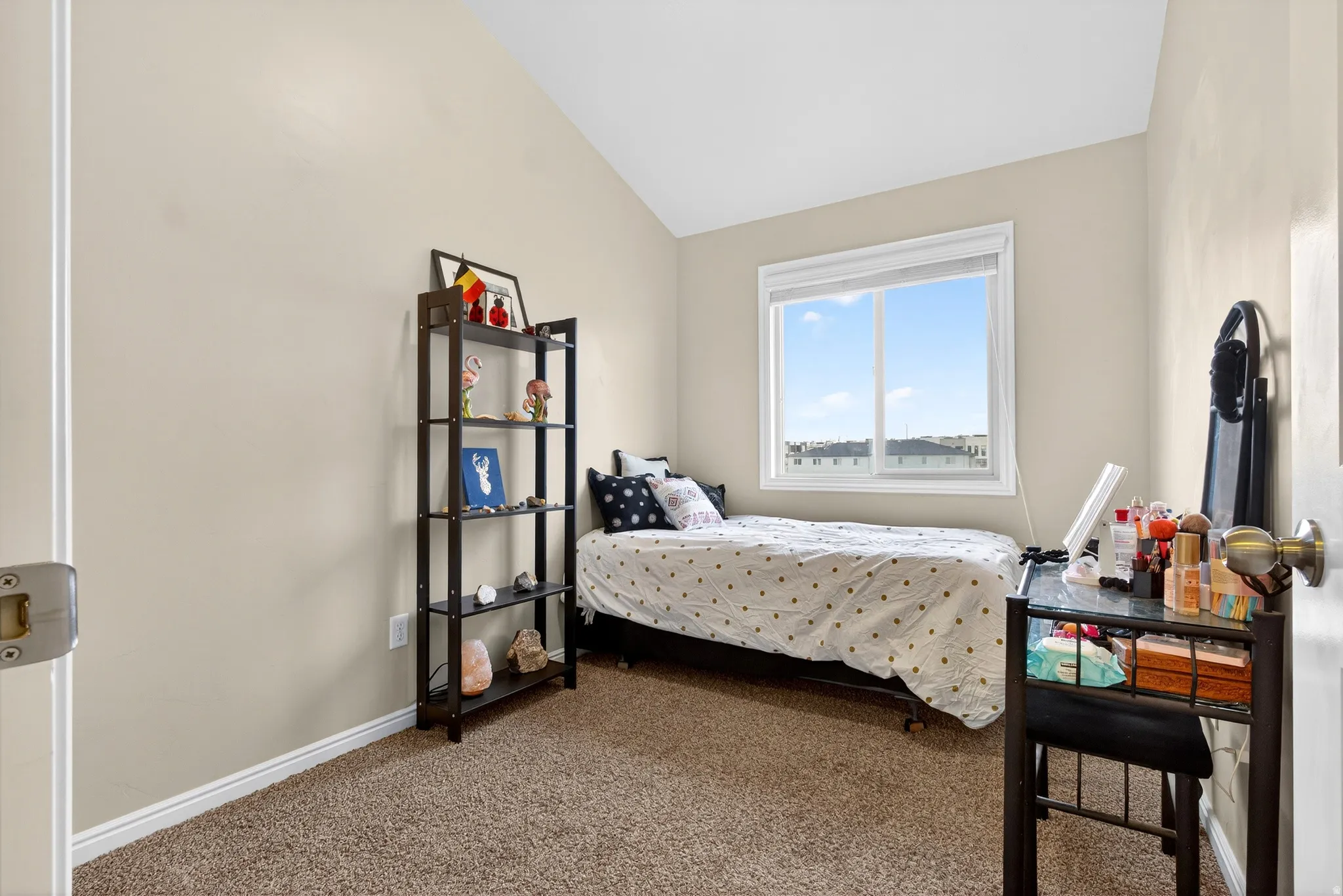 Carpeted bedroom with vaulted ceiling and baseboards