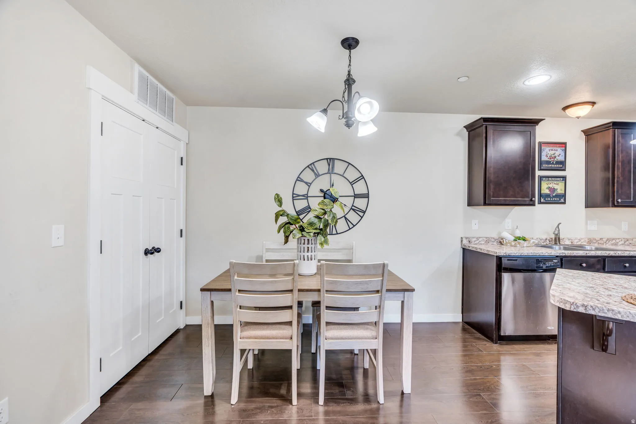 Dining space featuring hanging lights and dark wood-style floors
