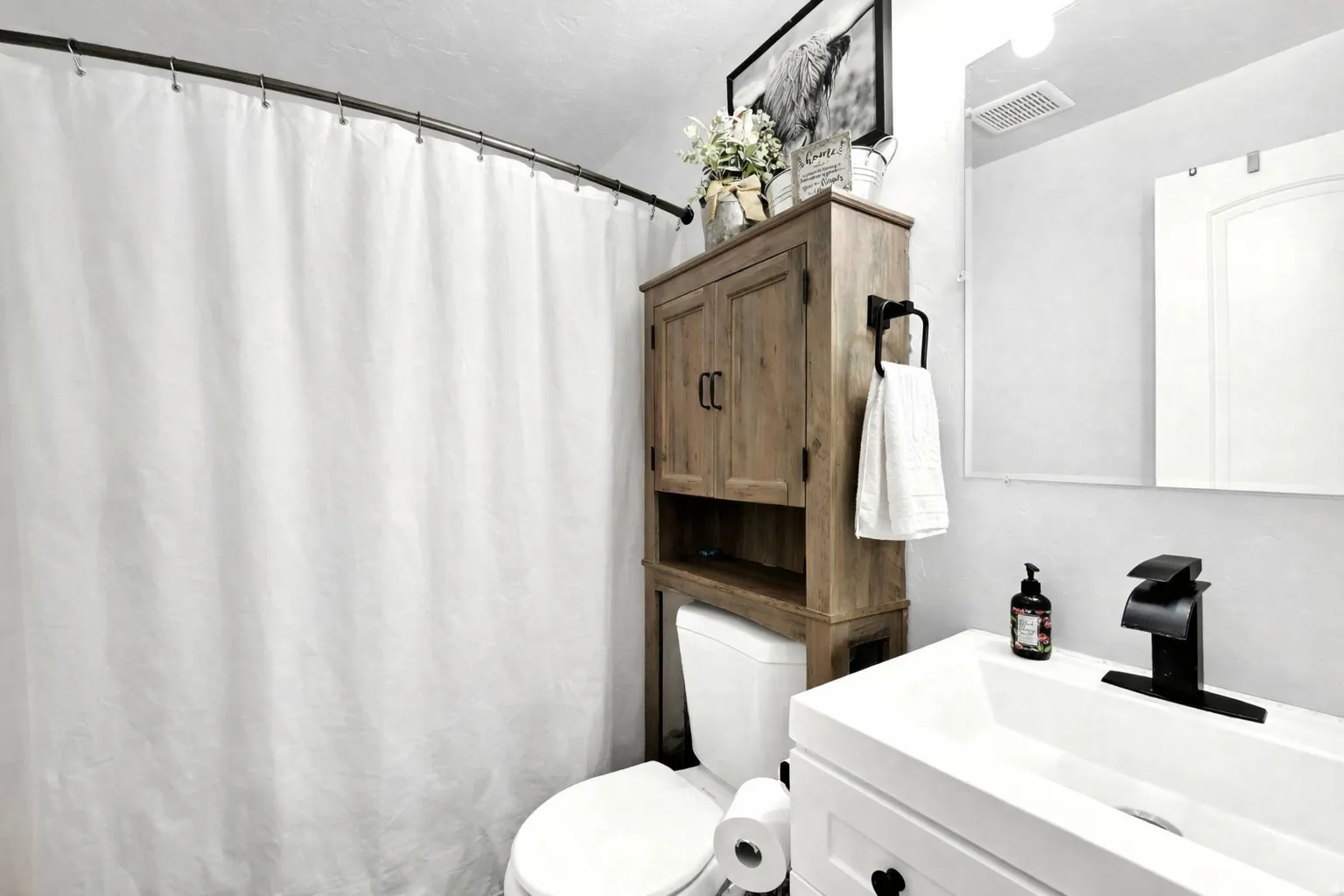 Bathroom featuring curtained shower and vanity