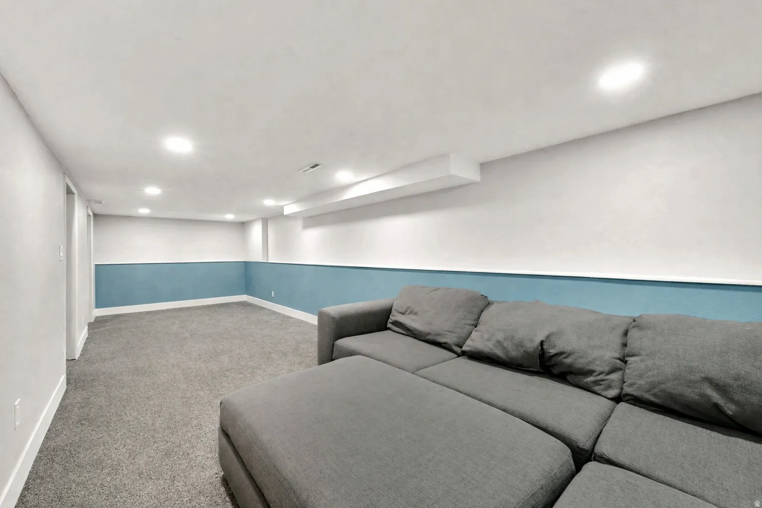 Carpeted living area featuring recessed lighting and baseboards