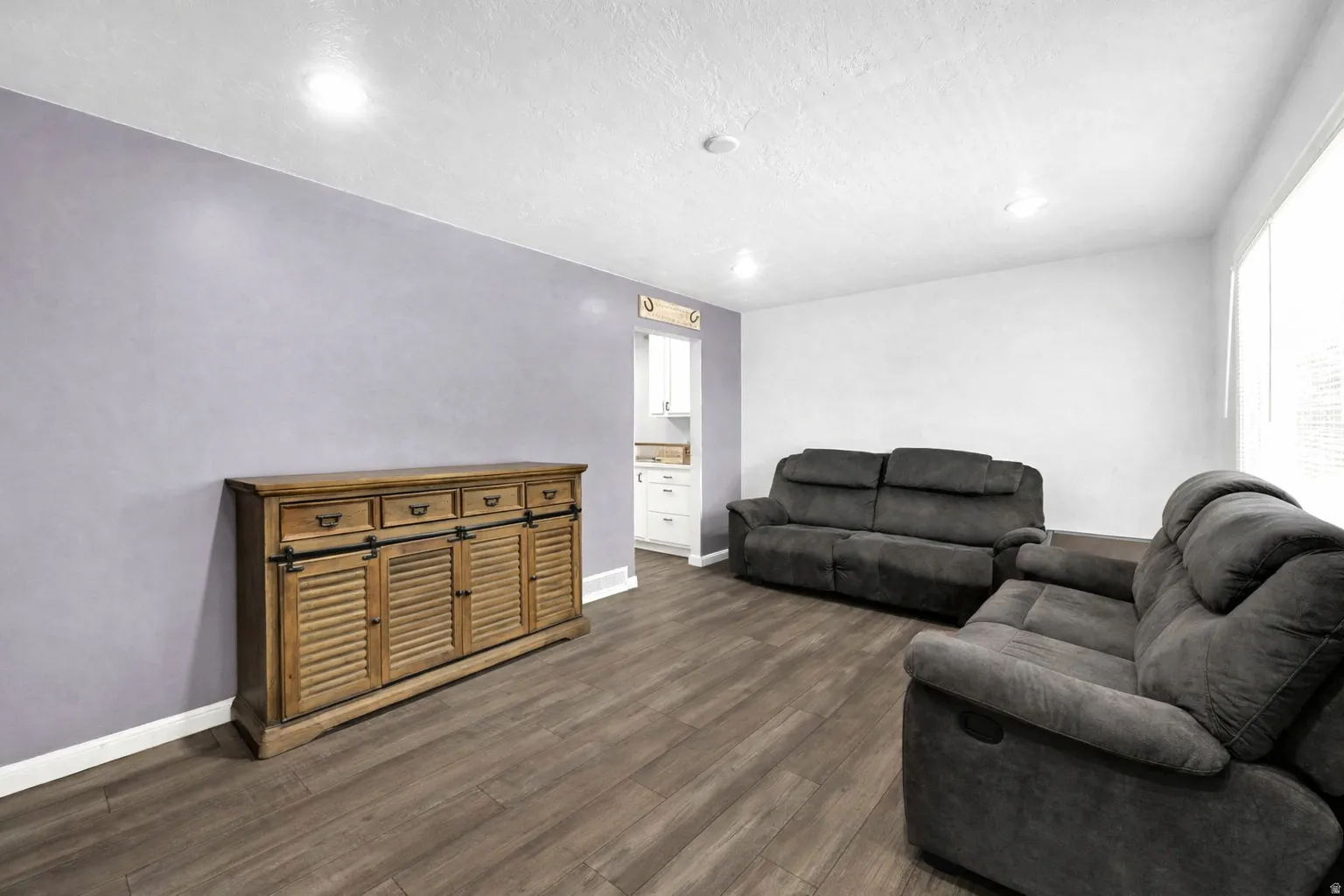 Living room featuring dark wood finished floors and baseboards